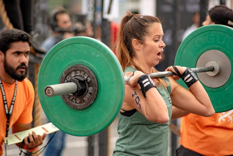 Woman lifting weights wearing earbuds