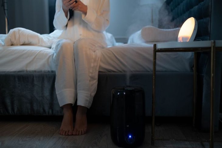 Humidifier releasing mist in a bedroom
