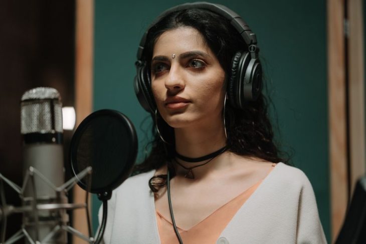 Singer recording vocals at a studio microphone